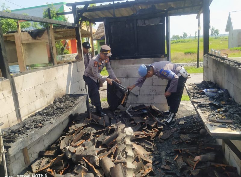 Aparat kepolisian saat melakukan evakuasi barang di warung yang terbakar di Magetan. Foto: ist