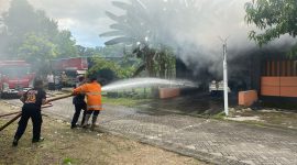 Petugas Pemadam Kebakaran sedang melakukan penyiraman ke mobil Datsun Go yang terbakar saat diparkir di garasi rumah di Ngawi, Kamis (18/4/2024). Foto: Neumedia.id/Fatihah