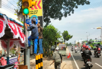 Dikeluhkan menutupi traffic light, Dishub Kabupaten Madiun pindahkan plang pos polisi di pertigaan Sekelip, Kamis (8/8/2024).