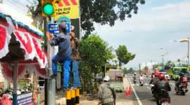 Dikeluhkan menutupi traffic light, Dishub Kabupaten Madiun pindahkan plang pos polisi di pertigaan Sekelip, Kamis (8/8/2024).