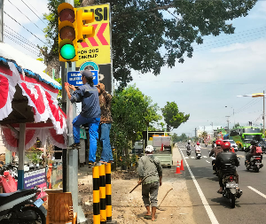 Dikeluhkan menutupi traffic light, Dishub Kabupaten Madiun pindahkan plang pos polisi di pertigaan Sekelip, Kamis (8/8/2024).