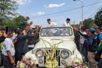 Naik Jeep, Paslon HARMONIS disambut gempita ribuan massa pendukung saat daftar di KPU Kabupaten Madiun, Rabu (28/8/2024) siang.