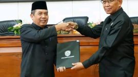 Pj. Bupati Madiun Tontro Pahlwanto (kiri) dan Wakil Ketua DPRD Kabupaten Madiun Slamet Rijadi menunjukkan bukti kesepakatan dalam sidang paripurna, Rabu (7/8/2024).