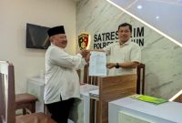 Ketua DPC PKB Kabupaten Madiun, Muhtarom (pakai peci) menunjukkan bukti pelaporan Lukman Edy di Satreskrim Polres Madiun, Senin (12/8/2024)