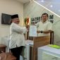 Ketua DPC PKB Kabupaten Madiun, Muhtarom (pakai peci) menunjukkan bukti pelaporan Lukman Edy di Satreskrim Polres Madiun, Senin (12/8/2024)